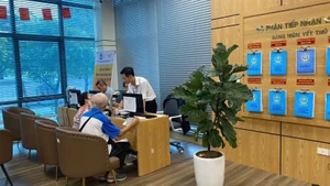 Người dân làm thủ tục hành chính trực tuyến tại Trung tâm phục vụ hành chính công thành phố Hà Nội, chi nhánh số 3. (Ảnh: DIỆU THƯƠNG)