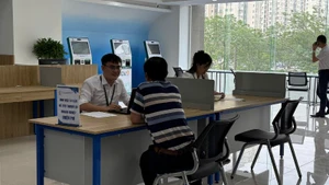 Người dân làm thủ tục hành chính tại Trung tâm phục vụ hành chính công thành phố Hà Nội, chi nhánh số 1. (Ảnh: DIỆU THƯƠNG)