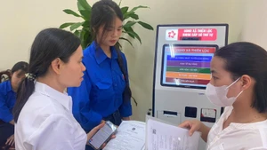 Đoàn thanh niên hỗ trợ người dân lấy số thứ tự tại Điểm Phục vụ hành chính công xã Thiên Lộc.