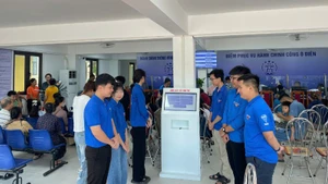 Đoàn viên thanh niên xã Ô Diên hỗ trợ người dân tại Điểm Phục vụ hành chính công xã. 