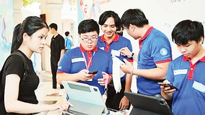 Các bạn sinh viên hướng dẫn các thí sinh dự thi tại Trường trung học phổ thông chuyên Lê Hồng Phong.