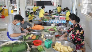 Gói bánh tét 3 màu tại làng nghề bánh tét Trà Cuôn, xã Vinh Kim, tỉnh Vĩnh Long.