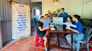 Đoàn viên, thanh niên tình nguyện hướng dẫn người dân nộp hồ sơ và trao giấy xác nhận mức độ khuyết tật tại nhà ở phường Cao Lãnh (tỉnh Đồng Tháp).