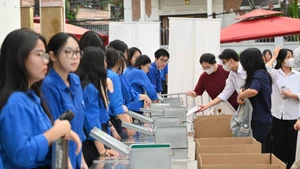 Thí sinh gửi lại các thiết bị, đồ dùng cá nhân trước khi vào phòng thi sáng 26/6 (Ảnh: THẾ ĐẠI)