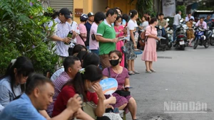 Phụ huynh chờ đợi trước điểm thi Trường trung học cơ sở Nguyễn Trường Tộ. (Ảnh: THẾ ĐẠI)