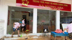 Cán bộ Phòng giao dịch Ngân hàng Chính sách xã hội Kỳ Sơn đồng hành cùng nhân dân xã Mường Xén khắc phục hậu quả lũ lụt.