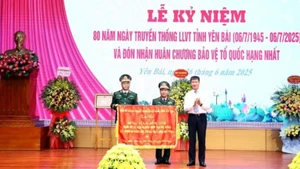 Đồng chí Bí thư Tỉnh ủy Yên Bái Trần Huy Tuấn trao cờ thêu cho Lực lượng vũ trang tỉnh. 