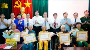 Bí thư Tỉnh ủy Nghệ An Nguyễn Đức Trung và các đại biểu chụp ảnh lưu niệm cùng 5 đảng viên lão thành cách mạng được trao Huy hiệu Đảng. (Ảnh: BP)