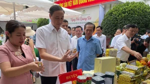 Các đại biểu tham quan gian hàng trưng bày các sản phẩm OCOP và nông sản tiêu biểu của các địa phương.