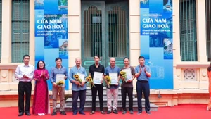 Bí thư Đảng ủy phường Cửa Nam Phạm Tuấn Long tặng hoa các tác giả có tác phẩm trưng bày tại triển lãm “Cửa Nam giao hòa - Cửa ngõ văn hóa, kết nối di sản, đổi mới sáng tạo”.