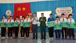 Đại diện lãnh đạo Ban Chỉ huy Bộ đội Biên phòng tỉnh Đắk Lắk và chính quyền địa phương trao quà tặng cho các em học sinh tại xã Ia Rvê.