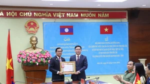 Được sự Ủy quyền của Thủ tướng Chính phủ Lào, đồng chí Leklai Sivilay trao tặng Huân chương Lao động hạng I của Chính phủ Lào cho đồng chí Nguyễn Đình Trung.