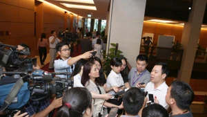 Phóng viên phỏng vấn đại biểu Quốc hội bên hành lang kỳ họp. (Ảnh: DUY LINH)