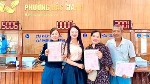 Đại diện Ủy ban nhân dân phường Bắc Gianh, tỉnh Quảng Trị cấp Giấy chứng nhận quyền sử dụng đất lần đầu cho các hộ gia đình theo quy định về thẩm quyền được giao. (Ảnh minh họa)
