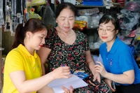 Bảo hiểm xã hội phối hợp với Bưu điện Nghệ An tuyên truyền chính sách bảo hiểm xã hội, bảo hiểm y tế đến người dân. (Ảnh: NGUYỄN ĐẠO)