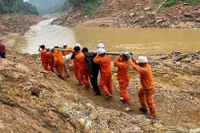 Công nhân vận chuyển máy móc, thiết bị vượt ghềnh đá để xuống thuyền, sau đó vượt qua quãng sông dài với nhiều đoạn thác nguy hiểm để đến được bản.