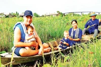 Du khách trải nghiệm đi xuồng khi nước lũ vừa vào đồng.