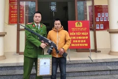 Công an xã Văn Lãng tặng quà và thư khen cho người dân giao nộp vũ khí tại trụ sở.