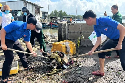 Đoàn viên thanh niên giúp người dân dọn bùn đất sau bão.