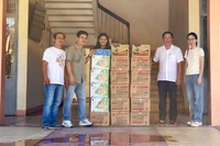 Lãnh đạo xã Quảng Điền thay mặt các trường học vùng ngập lụt trên địa bàn tiếp nhận 3.000 quyển vở và 2.000 cây viết từ phóng viên báo Nhân Dân và các mạnh thường quân.