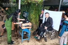 Công an xã Xím Vàng vượt suối, băng rừng đến từng nhà cấp đổi thẻ cho đảng viên đi lại khó khăn.