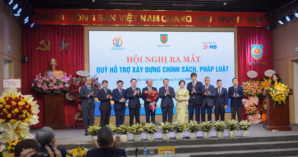 Bộ trưởng Tư pháp Nguyễn Hải Ninh tặng hoa và chúc mừng các thành viên Hội đồng quản lý Quỹ hỗ trợ xây dựng chính sách, pháp luật.
