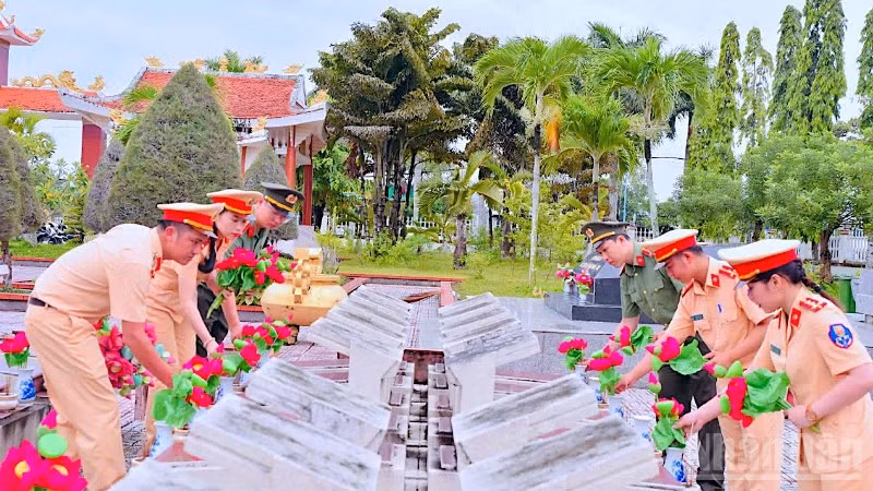 Cán bộ, chiến sĩ Công an Cà Mau chỉnh trang, dọn dẹp vệ sinh và thay mới hoa sen tại Nghĩa trang liệt sĩ tỉnh.