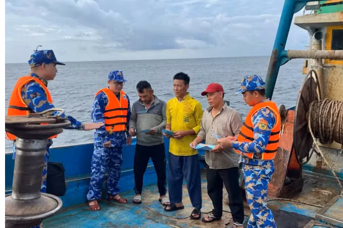 Cán bộ, chiến sĩ Bộ Tư lệnh Vùng Cảnh sát biển 3 phối hợp tuyên truyền về IUU cho ngư dân đang hành nghề trên vùng biển phía nam. Ảnh: MẠNH THẮNG
