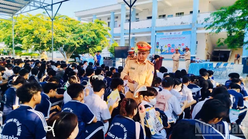Cán bộ Phòng Cảnh sát giao thông Công an tỉnh Cà Mau phát tờ rơi tuyên truyền cho các em học sinh tại trường Trung học phổ thông Sông Đốc (xã Sông Đốc, tỉnh Cà Mau).