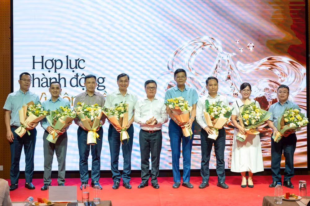 Đồng chí Lê Quốc Minh tặng hoa cho đại diện một số cơ quan báo chí, tổ chức truyền thông sẽ tham gia không gian thông tin chung về hoạt động vì cộng đồng. Ảnh: Thủy Nguyên
