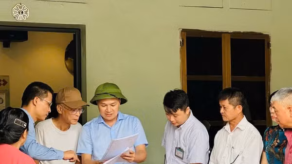 Chủ tịch Ủy ban nhân dân xã Thanh Oai (người thứ tư từ bên trái sang) đang vận động các hộ dân bàn giao mặt bằng để mở rộng Quốc lộ 21B.