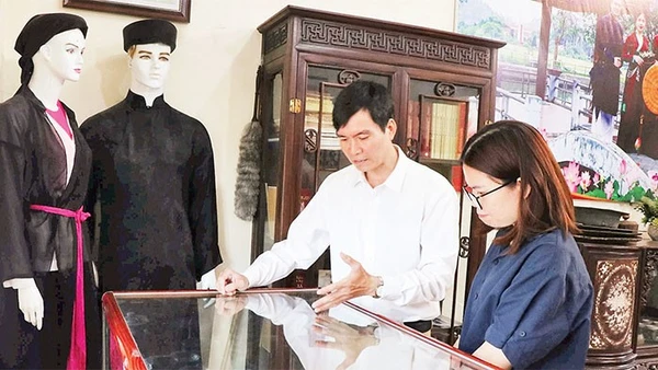 Liền anh Dương Đức Thắng giới thiệu các kỷ vật của người quan họ với du khách. 