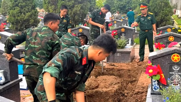Các đơn vị thực hiện khai quật, lấy mẫu hài cốt liệt sĩ tại Nghĩa trang liệt sĩ Nhổn. (Ảnh: Mai Hoa)