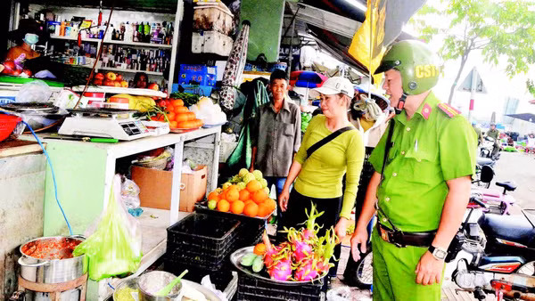 Công an phường Vũng Tàu nhắc nhở các tiểu thương giữ gìn trật tự lòng lề đường trong hoạt động kinh doanh, buôn bán. (Ảnh: ĐÌNH THÌN)