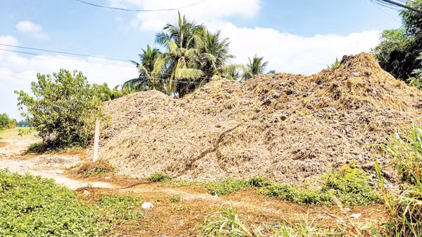 Đất mặt ruộng chất thành đống, được tập kết sát ven đường.