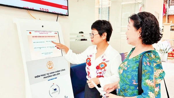 Hướng dẫn người dân lấy số thứ tự để thực hiện thủ tục hành chính tại Điểm tiếp nhận, phục vụ hành chính công phường Kim Liên (Hà Nội). (Ảnh: NGUYÊN BẢO)