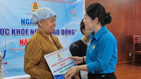 Bà Nguyễn Kim Loan, Phó Chủ tịch Liên đoàn Lao động Thành phố Hồ Chí Minh tặng quà cho lao động nữ bị bệnh hiểm nghèo. (Ảnh: Mai Chi) 