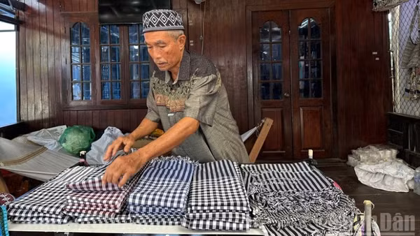 Ông Mohamad chăm chút cho từng sản phẩm dệt trưng bày tại cửa hàng.