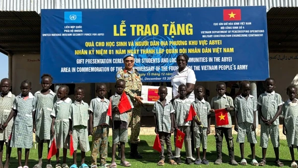 Trung tá Trần Thanh Sơn, Phó Đội trưởng Đội Công binh số 4, trao tặng dụng cụ học tập cho học sinh Abyei. (Ảnh: HẢI YẾN)