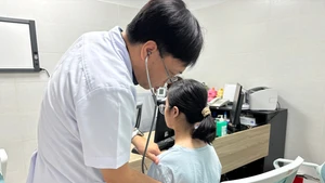 Bác sĩ khám lại cho bệnh nhân sau phẫu thuật.