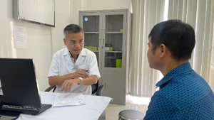 Tiến sĩ, bác sĩ Trần Huy Thọ, Phó Giám đốc Thường trực Bệnh viện Đặng Văn Ngữ, Viện Sốt rét-Ký sinh trùng-Côn trùng Trung ương tư vấn cho người bệnh đến khám bệnh lý ký sinh trùng. (Ảnh: THIÊN LAM)