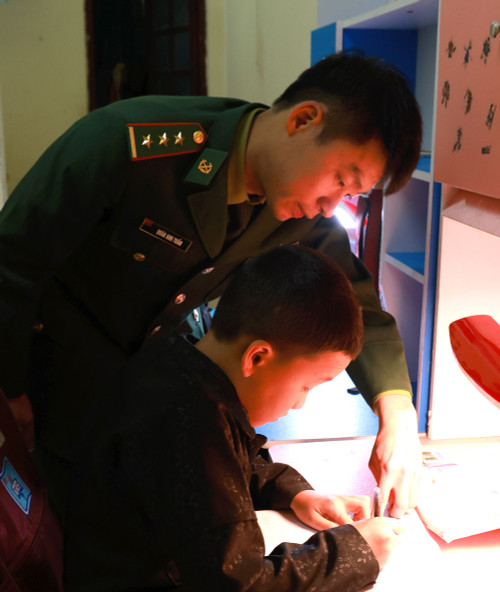 Thượng úy Quán Anh Tuấn dạy con nuôi của Đồn Biên phòng Lũng Cú.