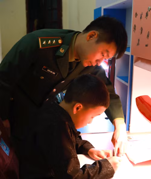 Thượng úy Quán Anh Tuấn dạy con nuôi của Đồn Biên phòng Lũng Cú.