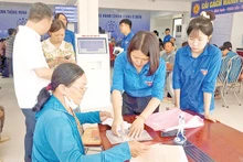 Đoàn viên, thanh niên xã Ô Diên hướng dẫn người dân rà soát lại hồ sơ trước khi nộp thủ tục hành chính.
