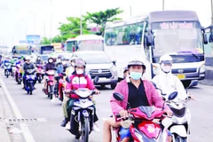 Xe máy lưu thông trên Quốc lộ 1, đoạn qua cầu Bình Điền. (Ảnh THẾ ANH)