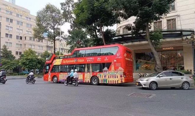 Xe buýt sử dụng ô-tô thoáng nóc chở khách du lịch tại trung tâm thành phố. (Ảnh: VÕ LÊ)