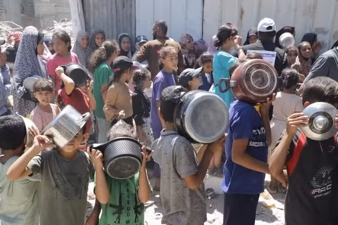 Trẻ em xếp hàng nhận thức ăn cứu trợ tại trại tị nạn Jabalia ở Dải Gaza. (Ảnh: THX/TTXVN)