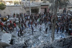 Người dân Palestine đứng giữa đống đổ nát của những tòa nhà bị phá hủy sau đòn không kích của Israel tại khu vực Al-Rimal, phía tây thành phố Gaza ngày 30/8/2025. (Ảnh: THX/TTXVN) 