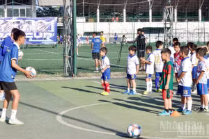 Các cầu thủ nhí học kỹ năng đá bóng cùng huấn luyện viên.