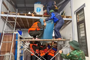 Lực lượng chức năng tỉnh Quảng Trị hỗ trợ người dân di chuyển tài sản lên nơi khô ráo. (Ảnh HIẾU MINH)